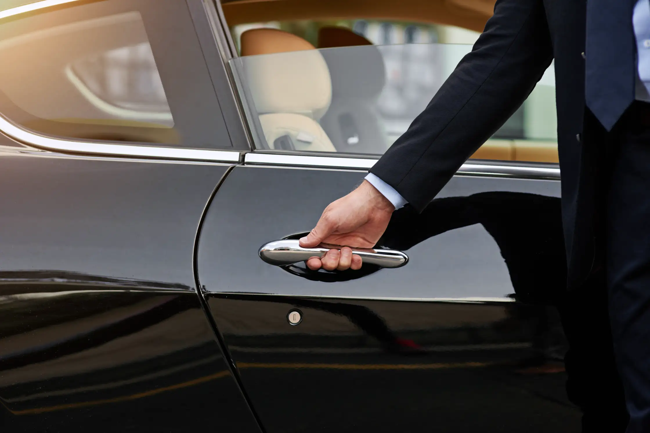 A chauffeur holds the door open.