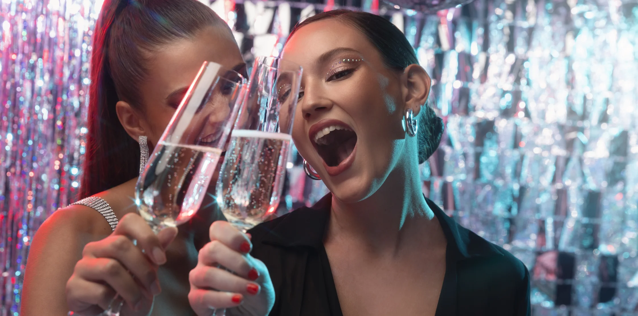 Girls at a nightclub party with champagne flutes in hand.